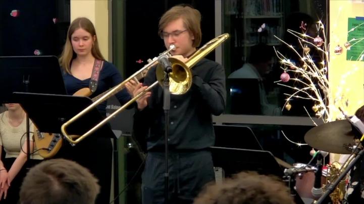Windows in the background. Students in black playing musical instruments